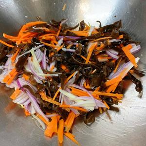 Stir-fry the wood ear mushrooms, carrot shreds, and onion shreds evenly.