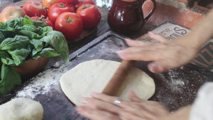 Divide the dough into 4 equal parts, take one part and flatten it slightly before rolling it into a round shape