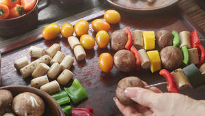 Skewer the vegan sausages, mushrooms, zucchini, and cherry tomatoes