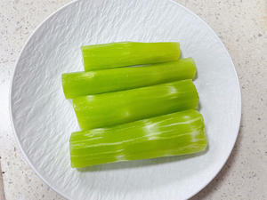 First, peel and wash the bamboo shoots. Then cut them into sections and slice them thinly.