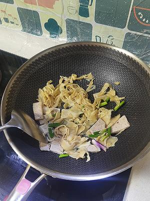 Heat oil in a pan, add bamboo shoots and pork slices to stir-fry until fragrant.