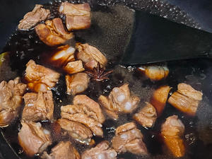 Add the original soup used to cook the ribs, enough to cover the ribs. Add a little salt, half a spoonful of dark soy sauce, a spoonful of soy sauce, a spoonful of rock sugar, and a spoonful of yellow wine.