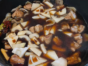 Add the dried potatoes and spring bamboo shoots. Cover with a lid and simmer.