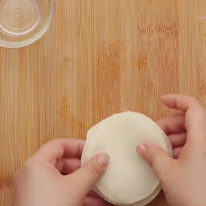 Spread oil on the dumpling wrappers, stack them one by one (about 6 wrappers together), and use a rolling pin to flatten the dumpling wrappers.