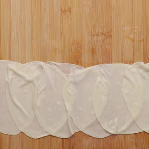 The oiled dumpling wrappers won't stick together, making them easy to separate. Arrange the flattened dumpling wrappers in a row.