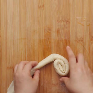 Roll the dumpling wrappers into a long strip, then shape it into a pancake.