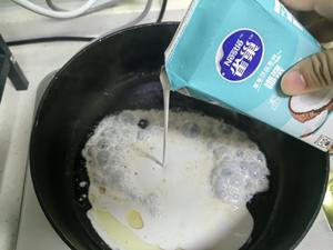 In the heated pan with the chicken fat, add half a box of Nestlé coconut milk, stirring to enhance the aroma.