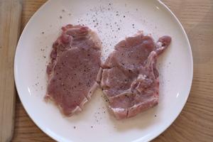 Place the pork on the plate, and sprinkle another layer of salt and pepper on top. Press down lightly, flipping it over to make sure both sides absorb the seasoning.