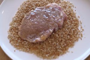 Place the pork in the baked breadcrumbs, sprinkling on both sides so that as much breadcrumb sticks as possible.