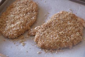 Pork cutlets coated on all sides with breadcrumbs are ready for the oven. Bake them at 200-220°C (about 392-428°F) for 12 minutes.