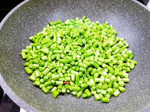 Heat a frying pan, add lard to melt, and stir-fry the cowpeas.