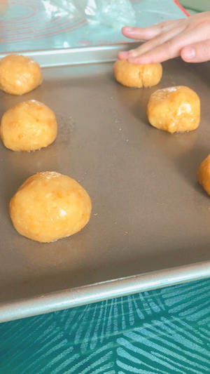 Divide the dough into 50g portions, roll them into balls and place them on a baking tray, using two fingers to press down and create a hole, which will still crack around.