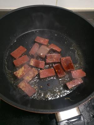 Heat oil in a pan, add a bit of minced ginger, and stir-fry the pig's blood for a while, then add some soy sauce.