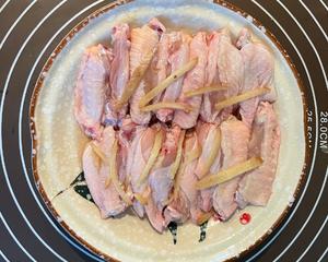 Clean the chicken wings and cut them down the middle (if not cutting completely, make a few slits on each side for better flavor absorption) and marinate with cooking wine and ginger strips for 10 minutes.