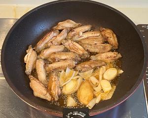 Once the chicken skin is browned and aromatic, add the green onions and ginger slices (I cut the ginger a bit bigger to easily remove it later and avoid accidental eating).