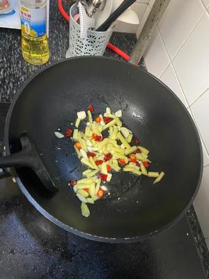 Sauté the ginger, garlic, and chili in a pan over low heat until fragrant.