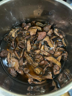 Take an appropriate amount of dried mushrooms (about two handfuls) and soak them in hot water until soft. Once they can be easily torn apart by hand, remove any stems, rinse away dirt, and squeeze out excess water. Don't throw away the soaking liquid; after letting the impurities settle, add the clear, flavorful broth to the chicken soup.