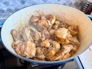 Pour in the light soy sauce (a layer over the chicken), dark soy sauce, cooking wine, and sugar—stir-fry.