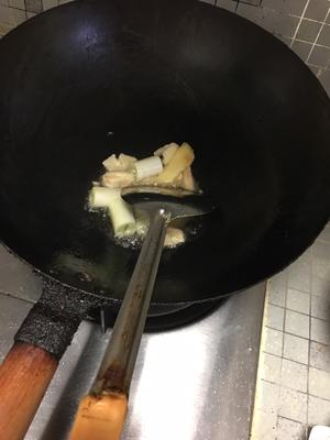 Heat oil in a pan, then add chopped ginger, garlic, and green onion to sauté until fragrant.