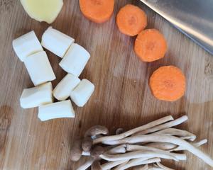 Clean and chop the tea tree mushrooms, carrots, Chinese yam, and ginger, and set them aside.