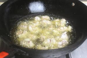 Once the oil reaches about 70% hot (bubbles form when chopsticks are inserted), add the coated bullfrog pieces. Fry them on medium heat until golden brown, then remove.