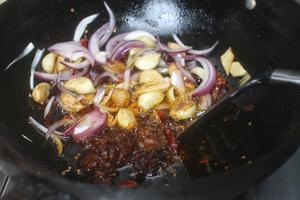 Add in the hot pot base and Pixian doubanjiang, and stir-fry on low heat until aromatic.