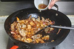 Add the bullfrog pieces along with cooking wine and soy sauce, and stir-fry until evenly mixed.