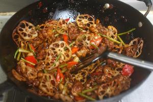 Finally, add the fried lotus root slices and a pinch of sugar, stir-frying well. It's ready to be plated now!