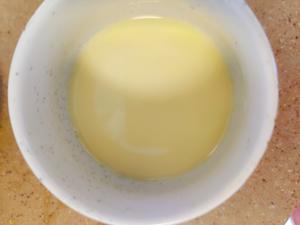 Whisked the egg yolks together and added 45 milliliters of warm water. Skimmed off bubbles with a spoon for a smoother texture.