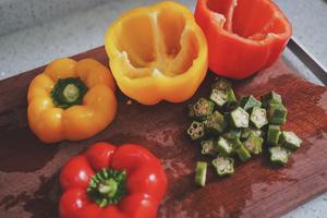 Wash the bell peppers, cut them near the stem, or slice them horizontally. Slice the okra.