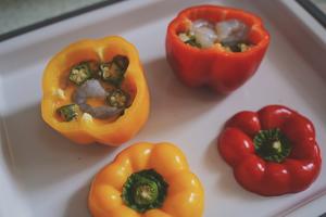 Lay the bell peppers flat, pour in the egg mixture, and add the shrimp and okra.