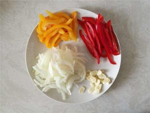 Slice the bell peppers into strips, chop the onion, and finely chop the garlic and ginger for later use.