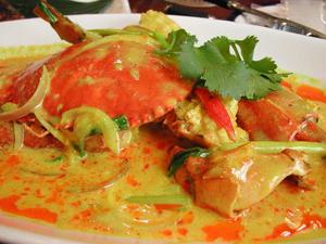 Return the crab to the pot, adding a small amount of salt and sugar. After 5 minutes, add the bell peppers and lemon slices, pour in the remaining coconut milk, and cook until slightly thickened before plating.