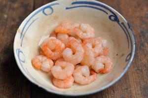 Blanch the shrimp in boiling water until they change color, then remove.