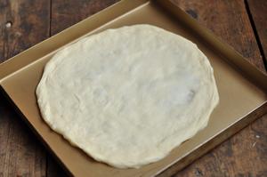 Flatten the rested dough into a thin crust; you can also use a rolling pin, but I usually stretch it by hand. Let it continue to ferment for about half an hour.