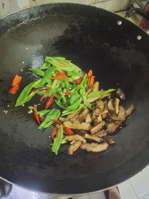 Heat oil in a pan; once hot, add the shiitake mushrooms to sauté and remove excess moisture, then add green and red peppers and stir-fry evenly.