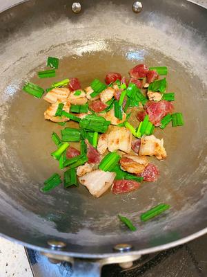 Add garlic leaves and stir-fry briefly, then mix in salt, light soy sauce, dark soy sauce, and oyster sauce until evenly distributed.