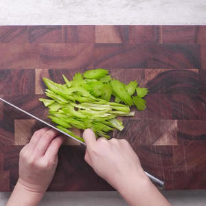 Slice the celery at a diagonal into thin pieces.