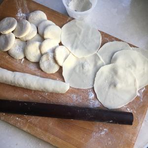 Divide the rested dough into small pieces and roll each into a wrapper.