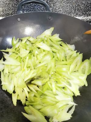 When the aroma of garlic and green onion rises, add the celery slices and stir-fry quickly over high heat.