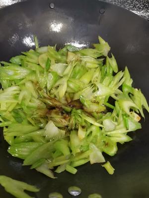 Once the edges of the celery slices turn transparent, add the five-spice powder and seafood soy sauce. If you don't have seafood soy sauce, regular light soy sauce can be used instead.