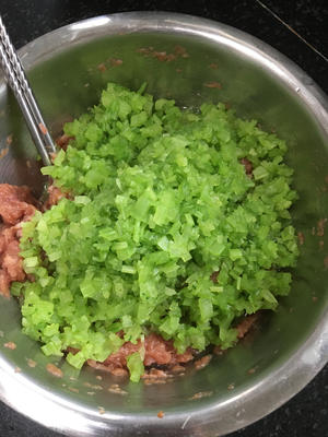 Add the chopped celery to the meat mixture along with vegetable oil and sesame oil.