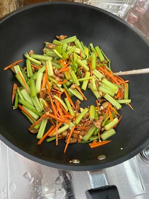 Add all the vegetables and stir-fry on high heat for a few moments until they're just cooked. Add a small half bowl of water and start seasoning: a teaspoon of salt, a bit of MSG, a tablespoon of soy sauce, and a spoonful of dried red chili powder. If you have it, add a bit of Liuyang fermented black bean.