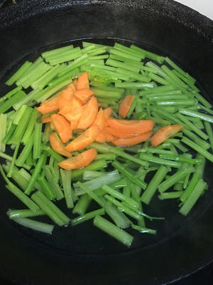 Add water to a pot, bring to a boil over high heat, add half a tablespoon of salt, a few drops of cooking oil, stir well, then add the celery and carrot🥕. Blanch for forty seconds.