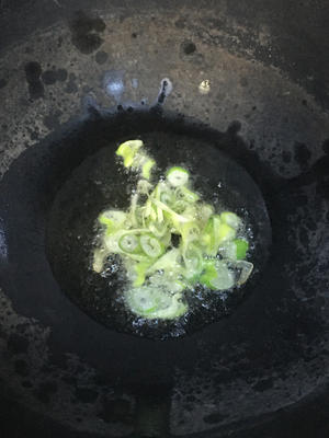 Heat oil in a pan; when hot, sauté the scallions until fragrant.