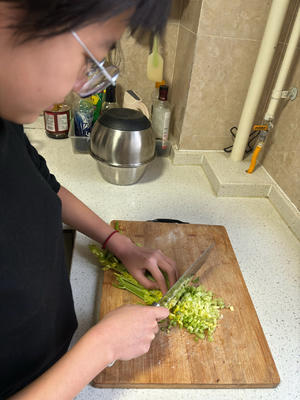 Chop the celery finely, squeeze out the excess moisture, and mince the pork, placing it all in a bowl.