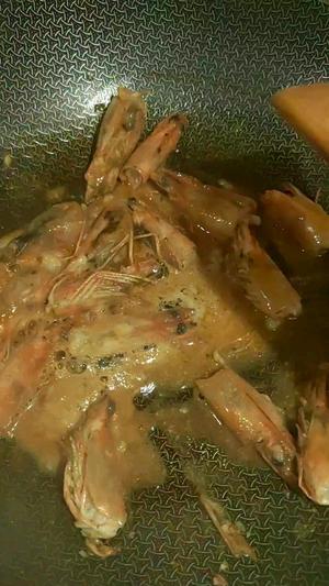 Add a small amount of oil to the pot, toss in the fresh shrimp heads, and sauté on low heat while pressing them down with a spatula.