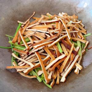 Once the celery is wilted, add the tofu strips to the pan. Stir-fry on high heat until the tofu releases its aroma, then season with a little salt and monosodium glutamate.