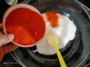 While the glutinous rice paste is still hot, add one bowl of chili powder and stir well.