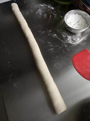 Knead the rested or risen dough until it's smooth, roll it into a long strip, and cut it into pieces weighing about 30-35 grams. Cover them with plastic wrap to prevent drying.